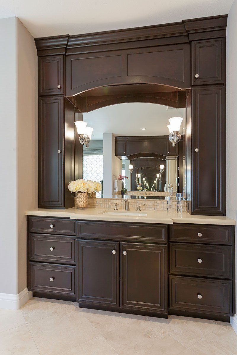 Dark wood bathroom vanity with mirror, marble countertop, and built-in storage drawers
