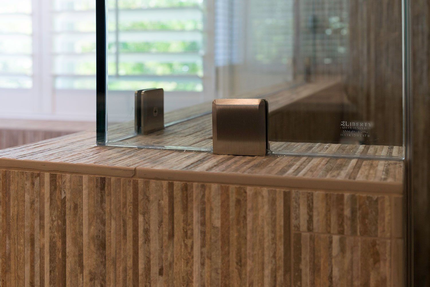 Two small brown devices on a wooden table beside a glass partition