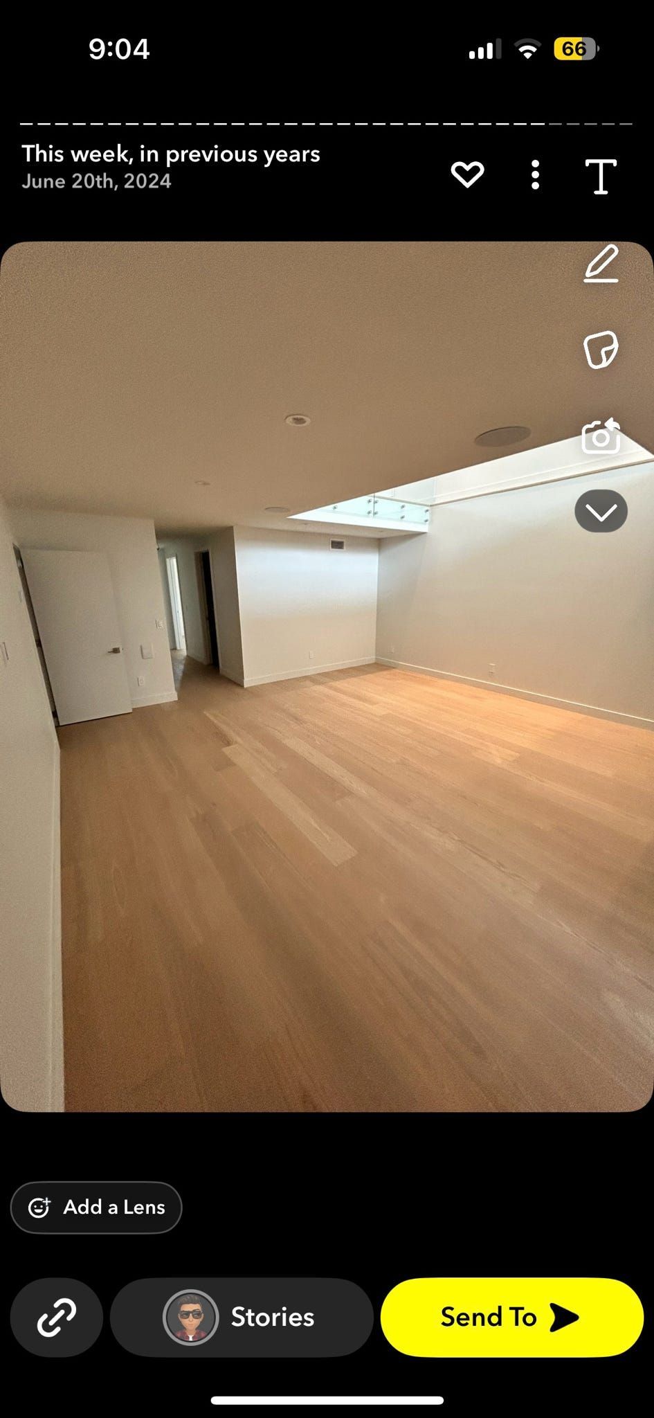 Pièce moderne vide avec parquet clair, murs blancs et éclairage lumineux au plafond.