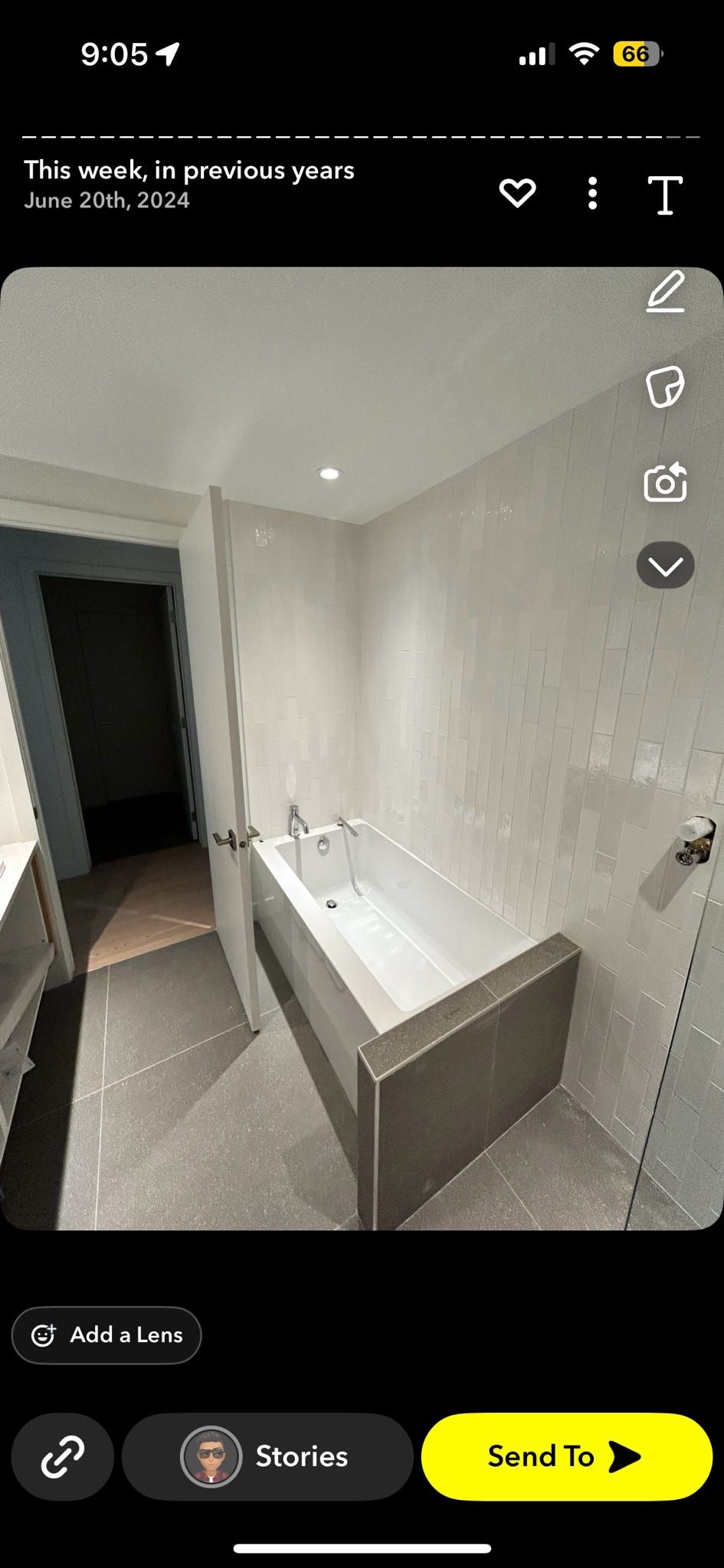 Salle de bains moderne avec baignoire blanche autoportante, grand miroir et douche à l'italienne.