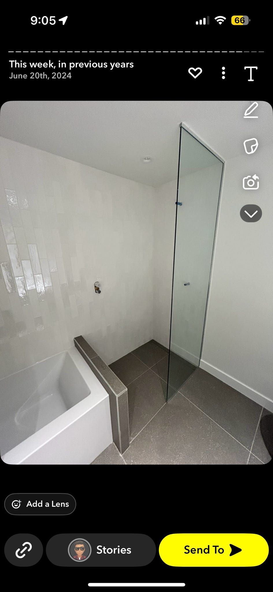 Petite salle de bains avec murs blancs, sol carrelé et cabine de douche en verre.