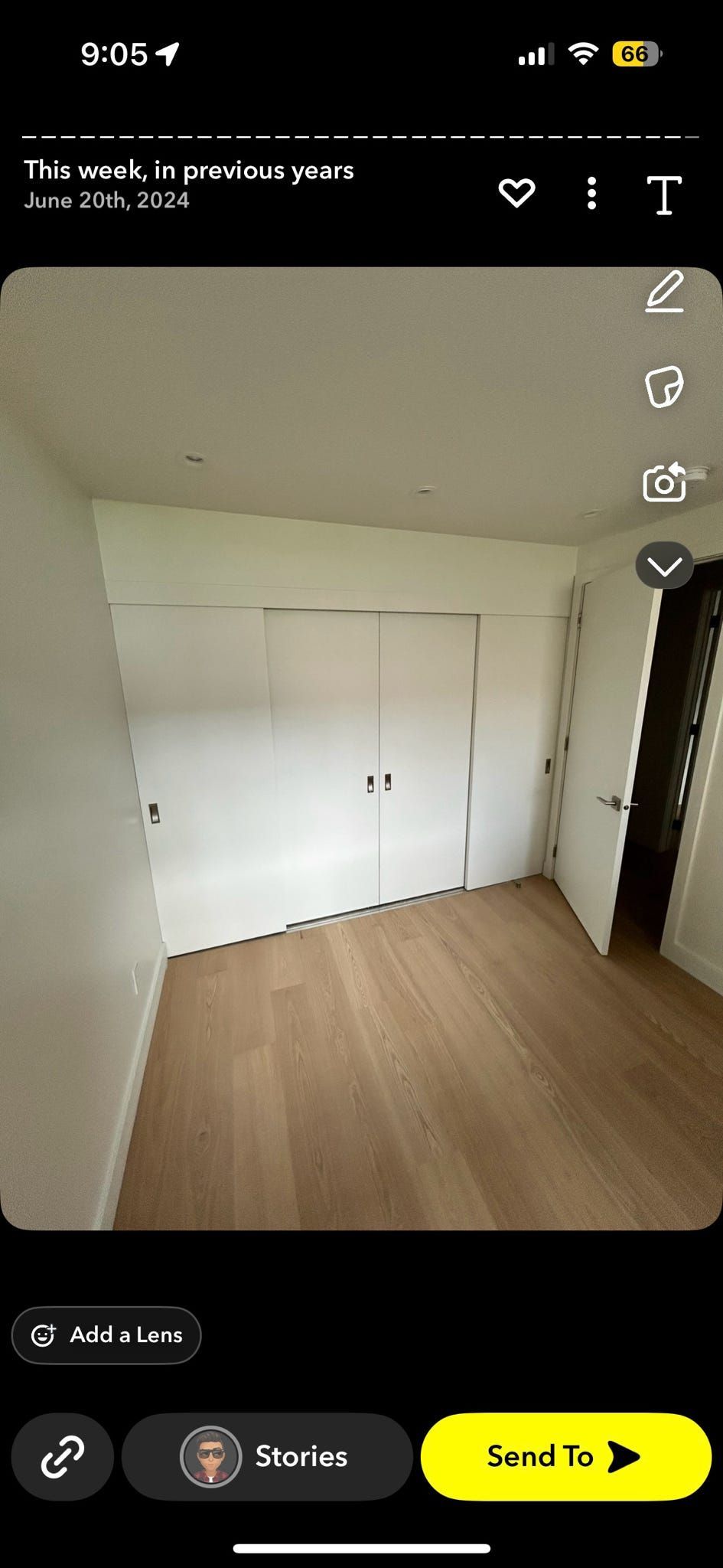 Placard blanc vide dans une petite pièce avec parquet clair et une porte sur la droite.