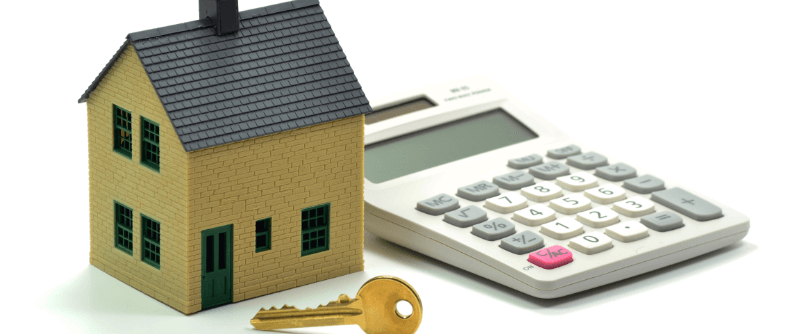 A small house next to a calculator and a golden key, all on a white background, suggesting home buying costs.