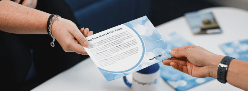 Hands passing a flyer with light blue design.