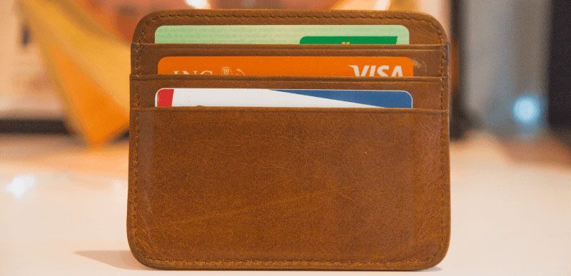 Brown leather wallet with several credit cards visible.