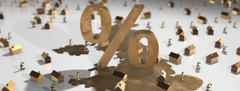 A 3D rendering of a 0% symbol casting a shadow of a map and surrounded by houses and British pound symbols.