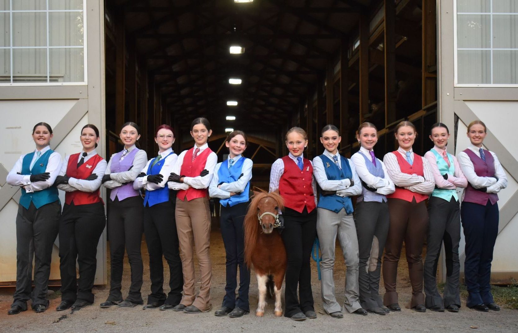 photo of Lenux Stables National Academy Team riders in show attire, standing in front of fence