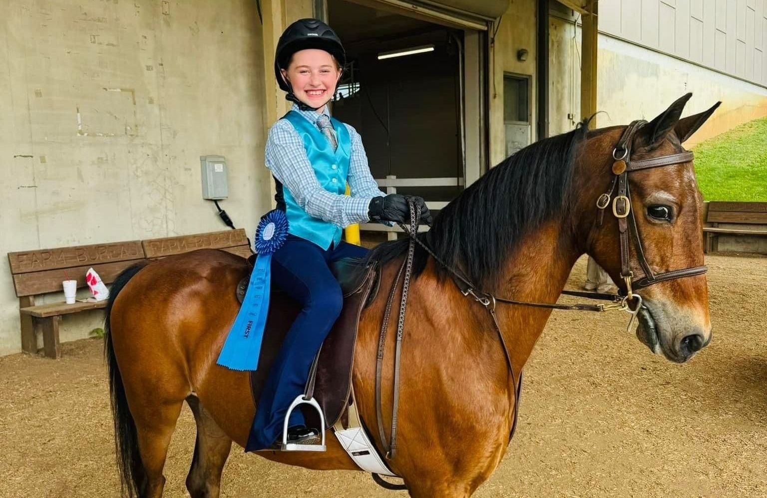 photo of Lenux Stables academy riders at horse show, holding saddles