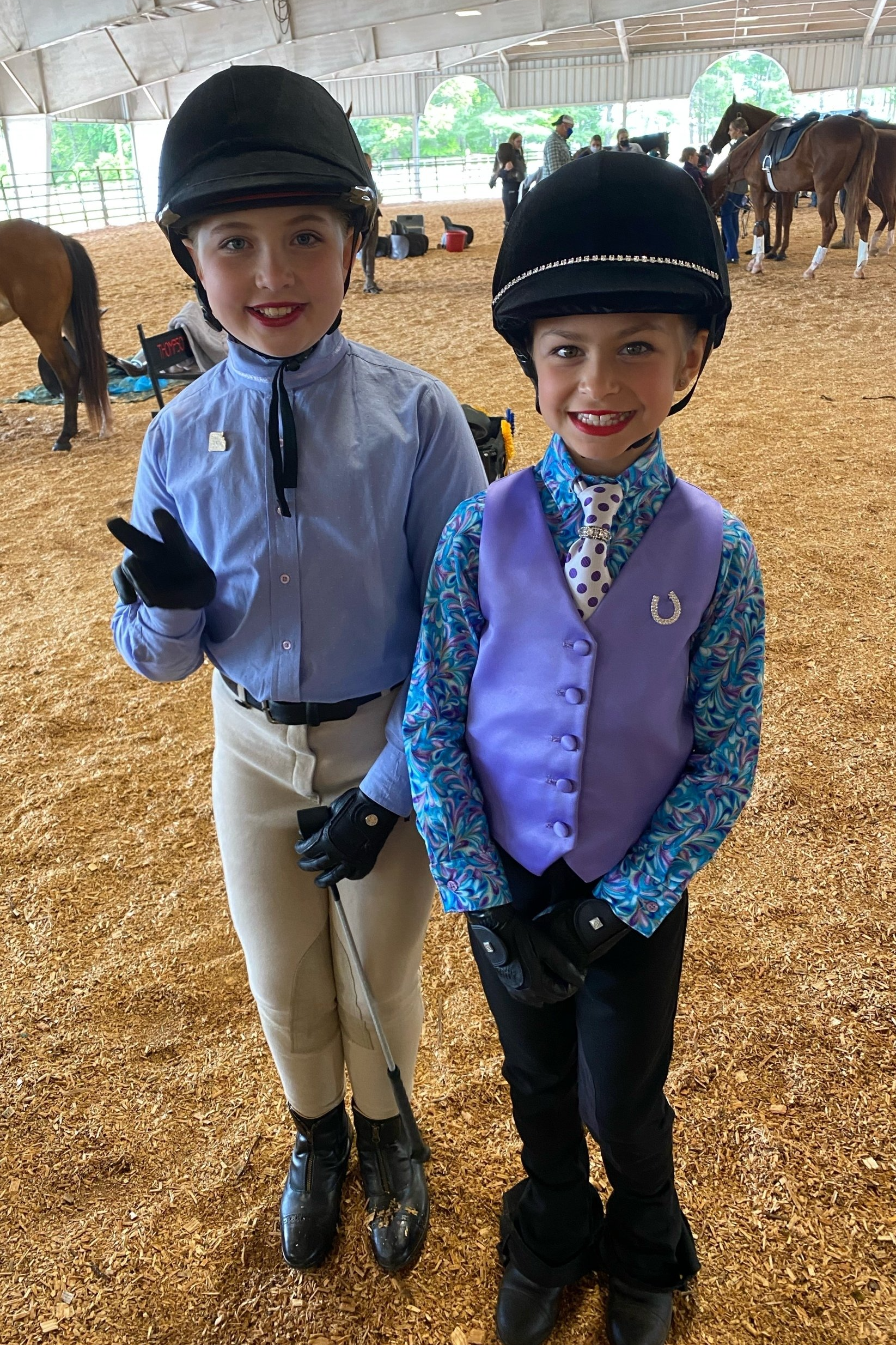 photo of two Lenux Stables academy riders standing in warmup ring prior to their class at horse show