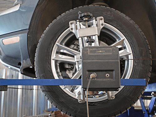 A car is being adjusted by a machine that says ' alignment ' on it