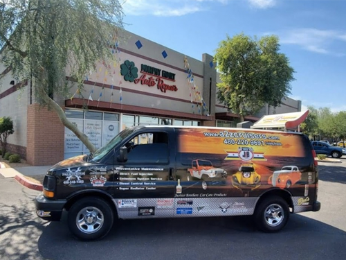 A van is parked in front of a building that says drive one auto repair
