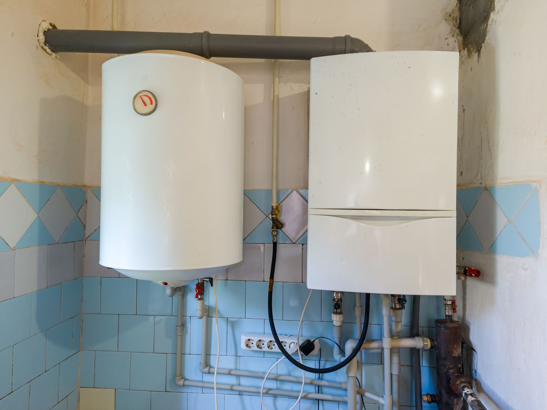 Person in green gloves installing a black under-sink garbage disposal unit.
