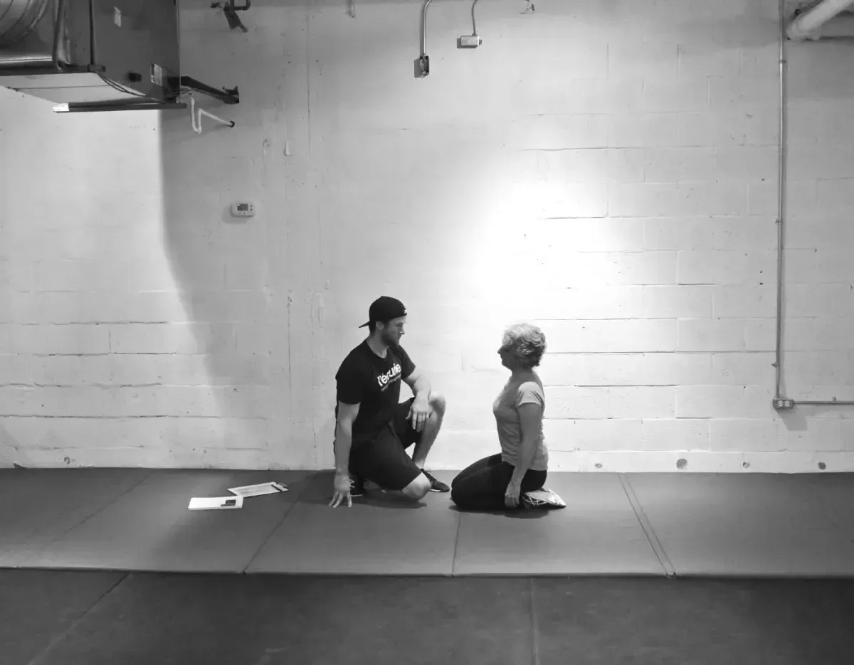 Deux personnes assises au sol dans une grande salle blanche &eacute;pur&eacute;e