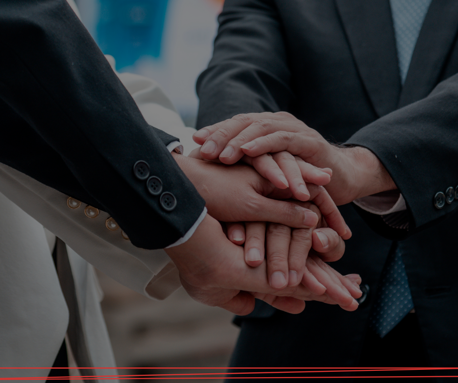Professionisti in giacca e cravatta uniscono le mani in un gesto di unità e collaborazione.