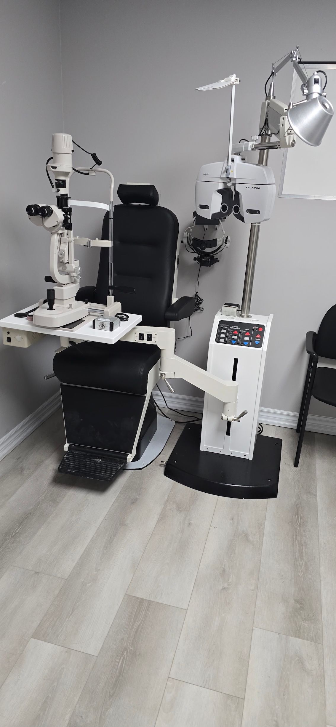 An ophthalmologist 's office with a chair and a machine.