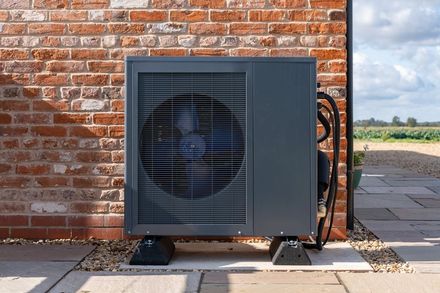 Black heat pump on slabs, outdoors.