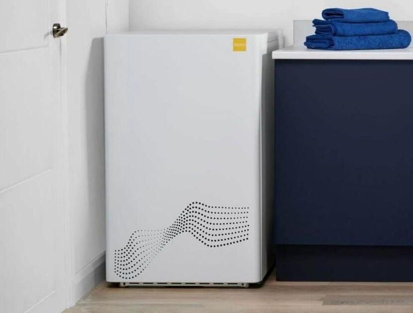 A stack of blue towels sits on a counter next to a white refrigerator