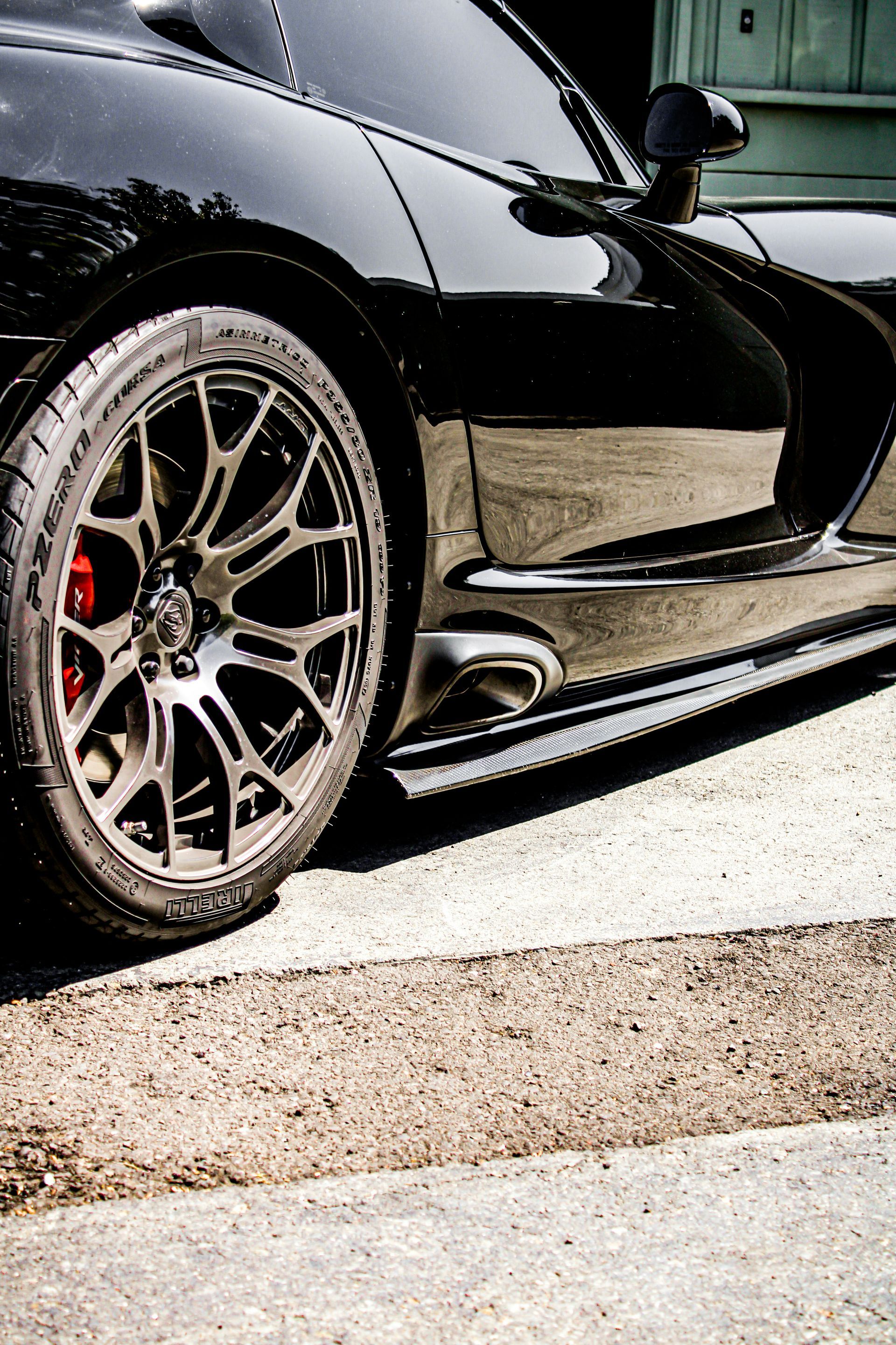 A black sports car is parked on the side of the road.