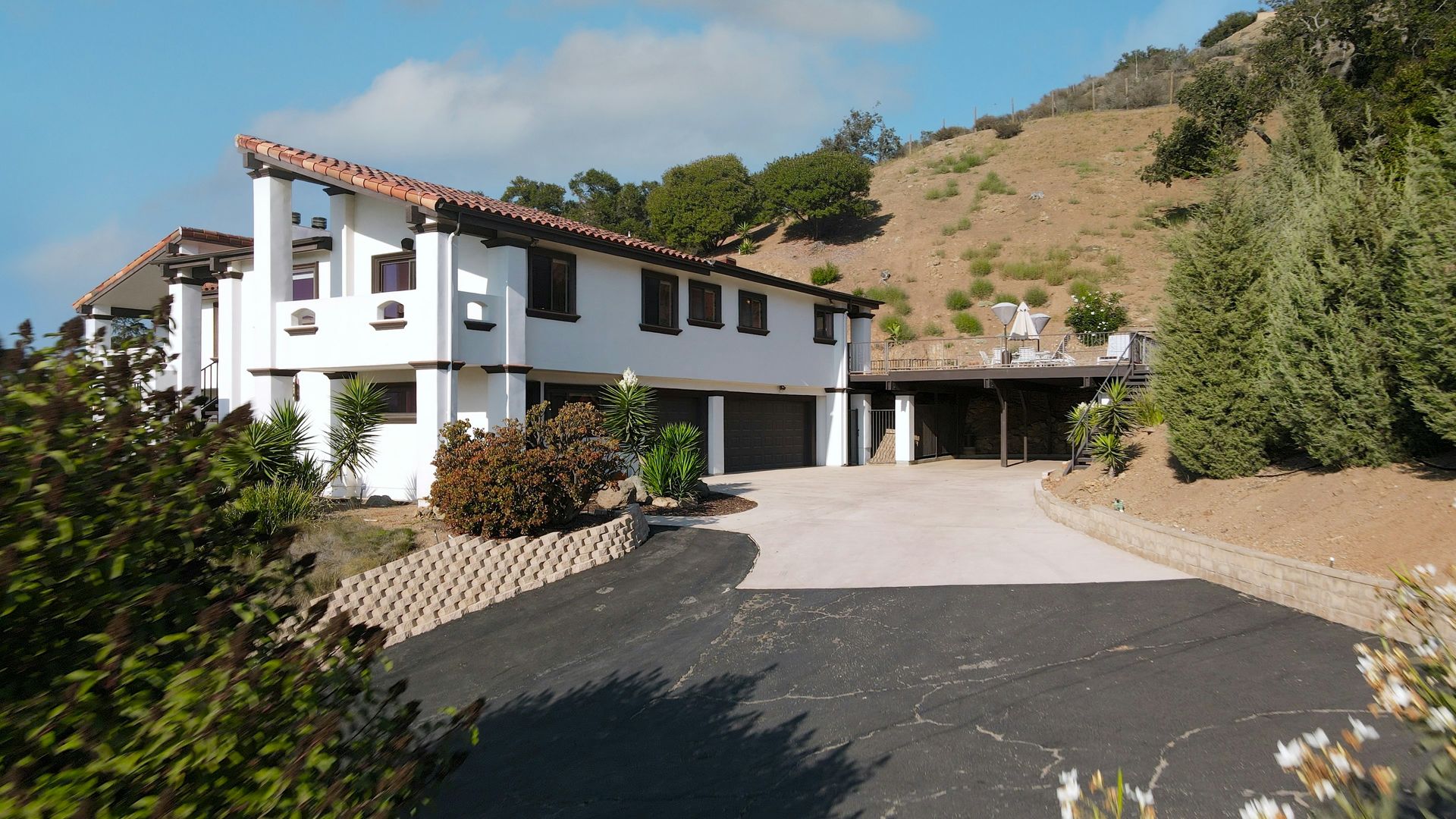 A large white house sits on top of a hill