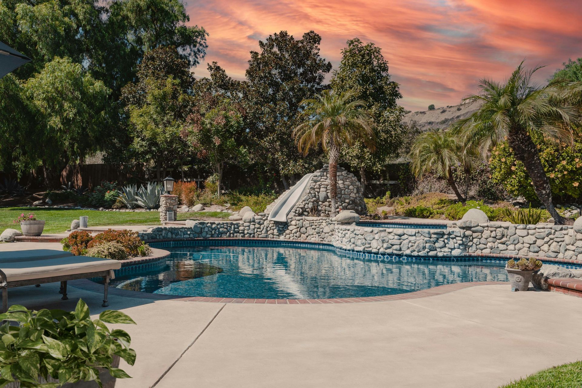 There is a large swimming pool in the backyard with a slide.