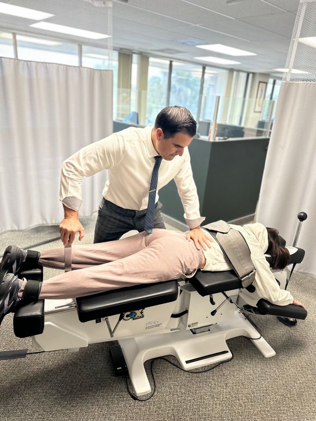 Doctor positioning patient on an examination table in a clinic office