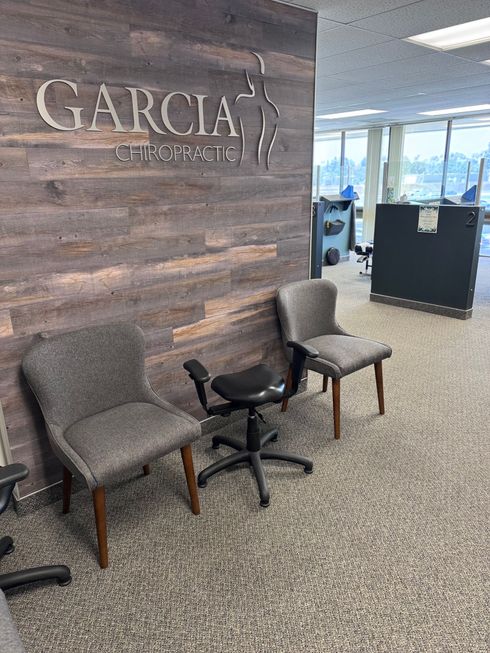 Empty office with desks, black privacy panels, carpeted floor, and large windows overlooking a city view