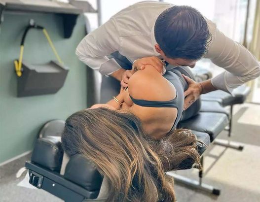 Chiropractor adjusting a woman lying on a treatment table in a clinic
