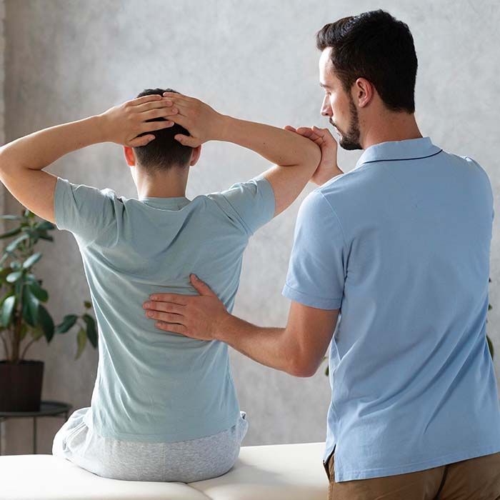 Therapist supporting a seated client with hands on head in a counseling room