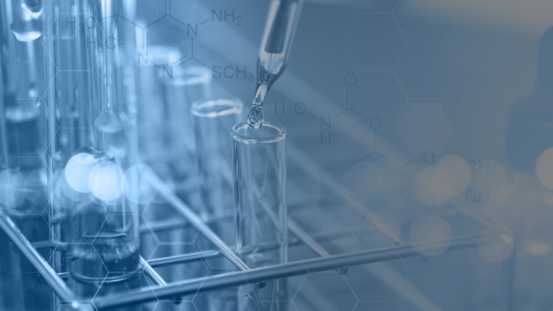 A pipette is pouring liquid into a test tube in a laboratory.