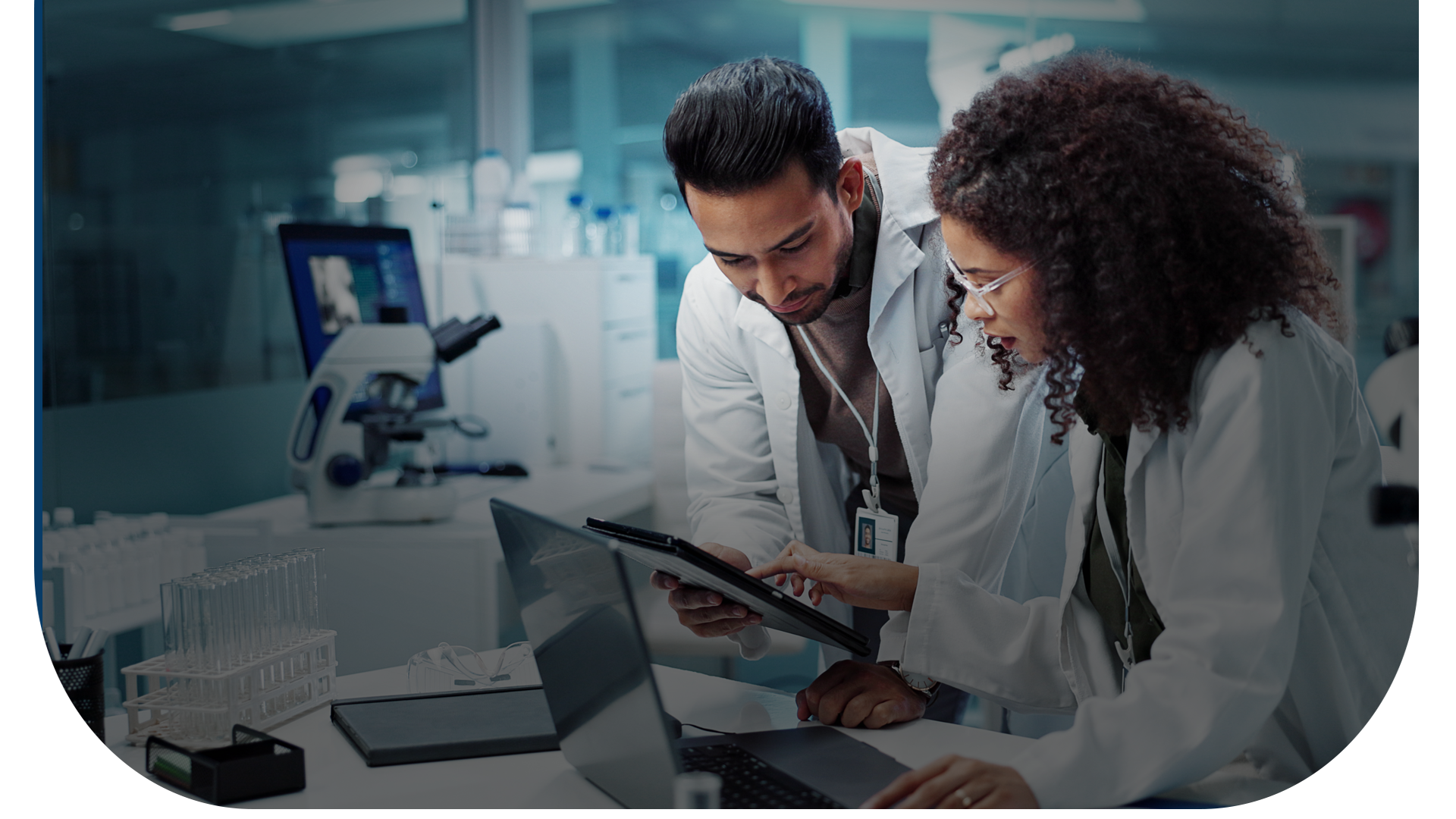 A man and a woman are looking at a laptop in a lab.