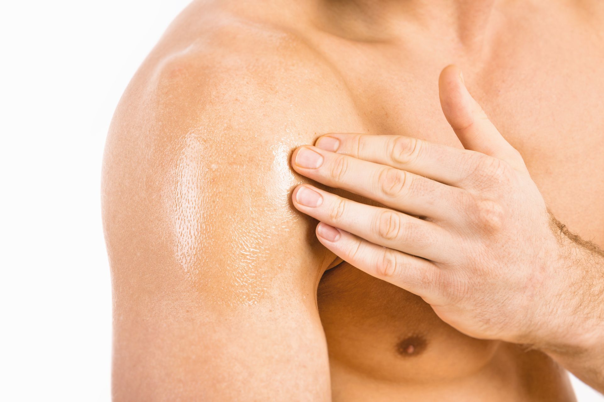Person applying lotion to shoulder and upper chest with a hand
