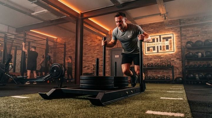 Member mid-sled-push during a CrossFit-style POWER class at HIIT West Hampstead