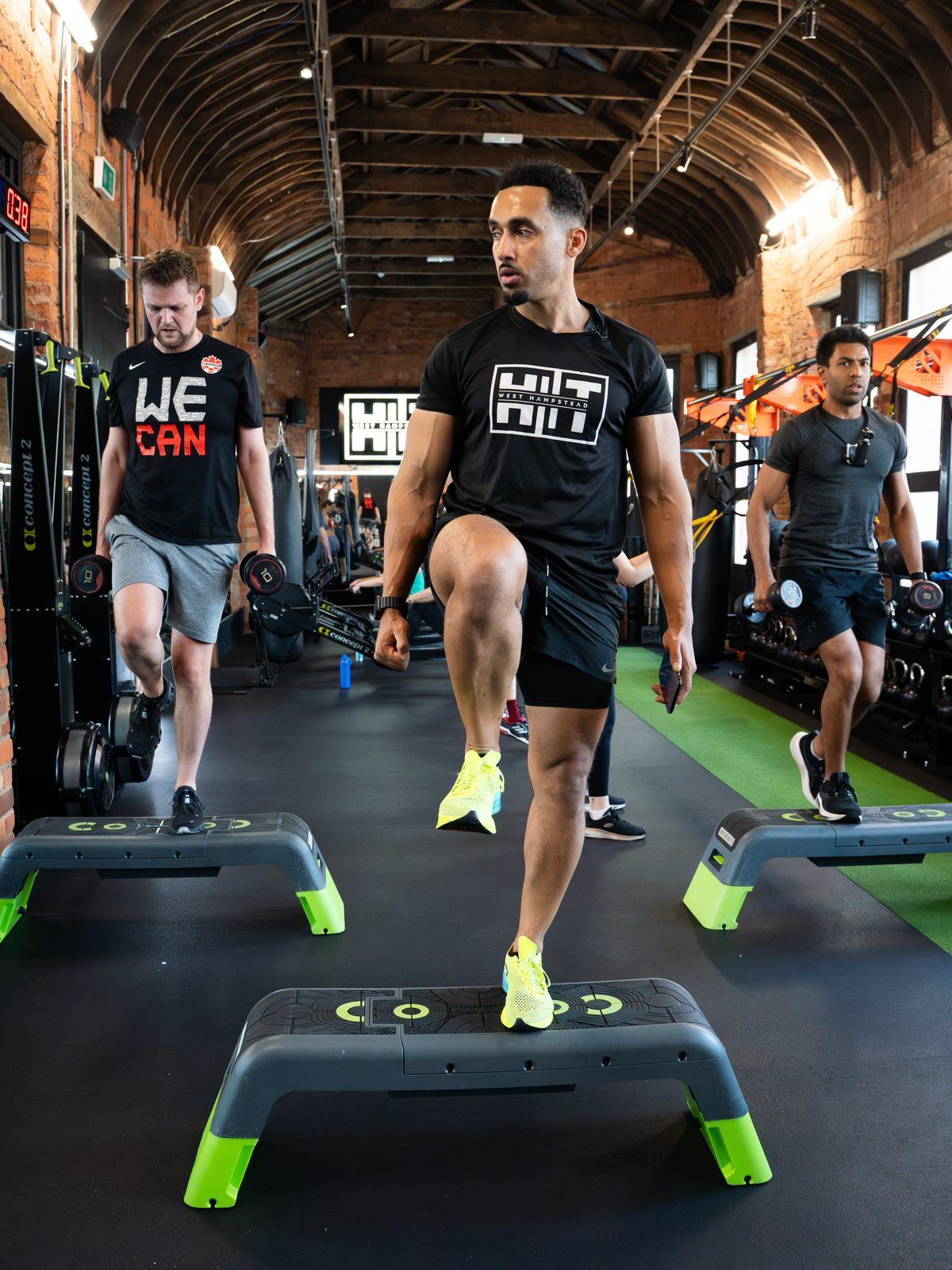 Member doing a high-knee step-up in a HIIT class at HIIT West Hampstead