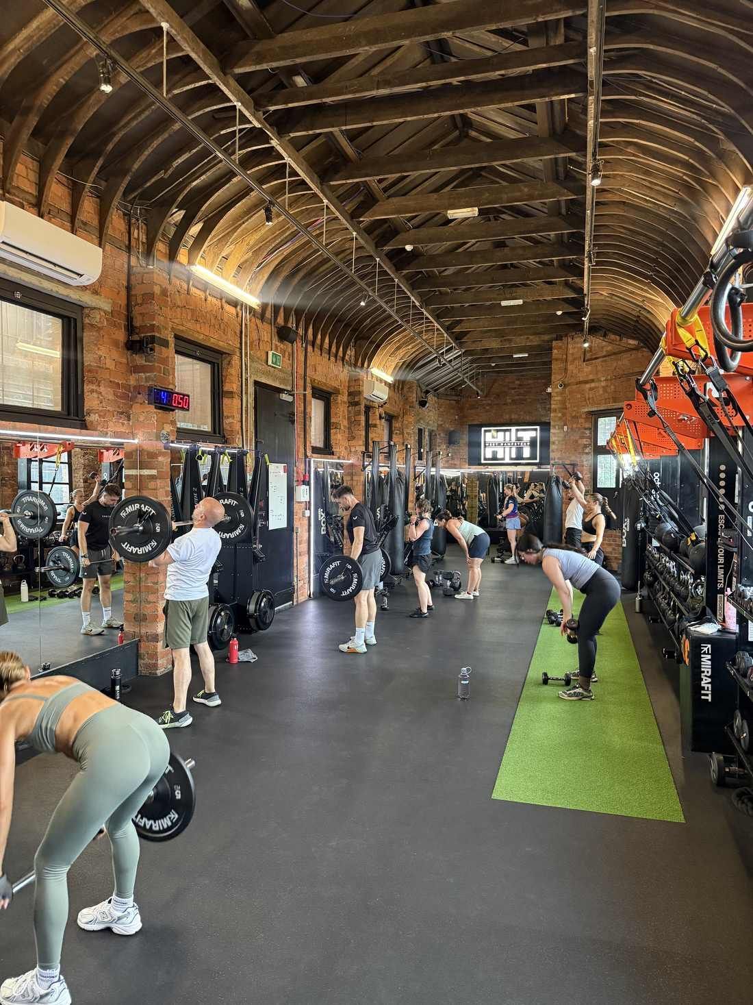 Members lifting barbells in a coached HIIT class at HIIT West Hampstead gym