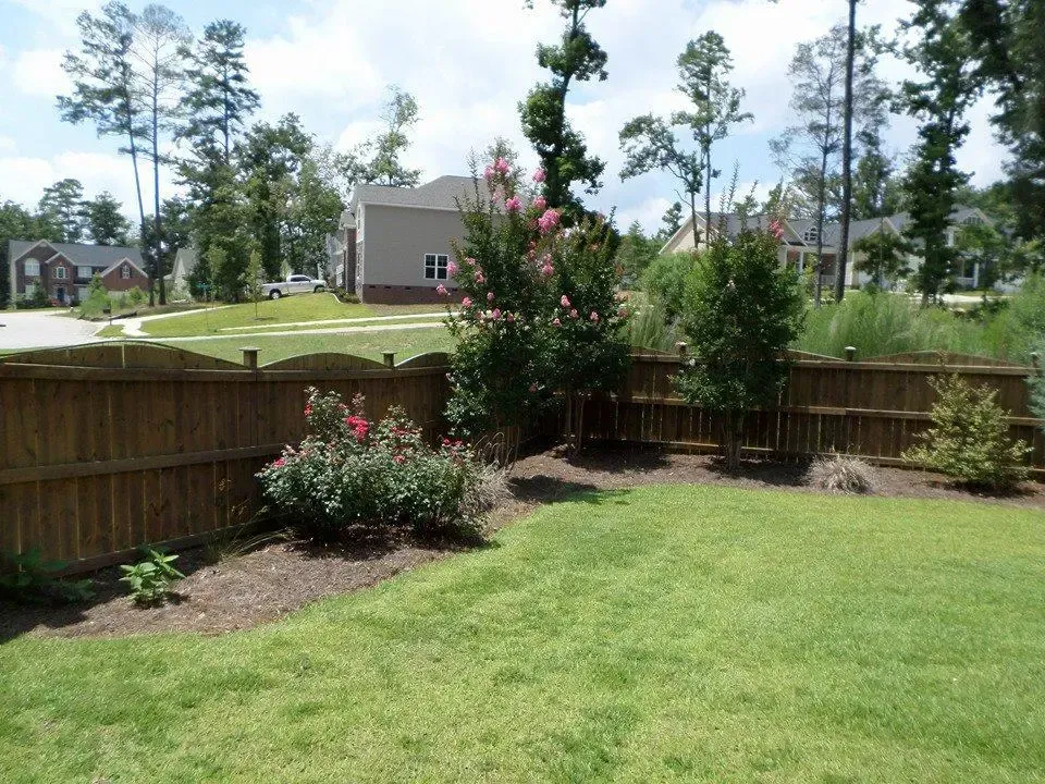 Honey Badger Lawn & Landscape
- A wooden fence surrounds a lush green yard