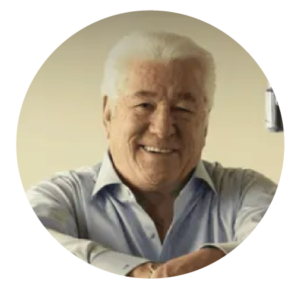 Smiling man with white hair in a light blue shirt, shown in a circular profile photo.