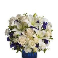 Blue vase holding a white and blue flower bouquet, featuring roses and lilies.