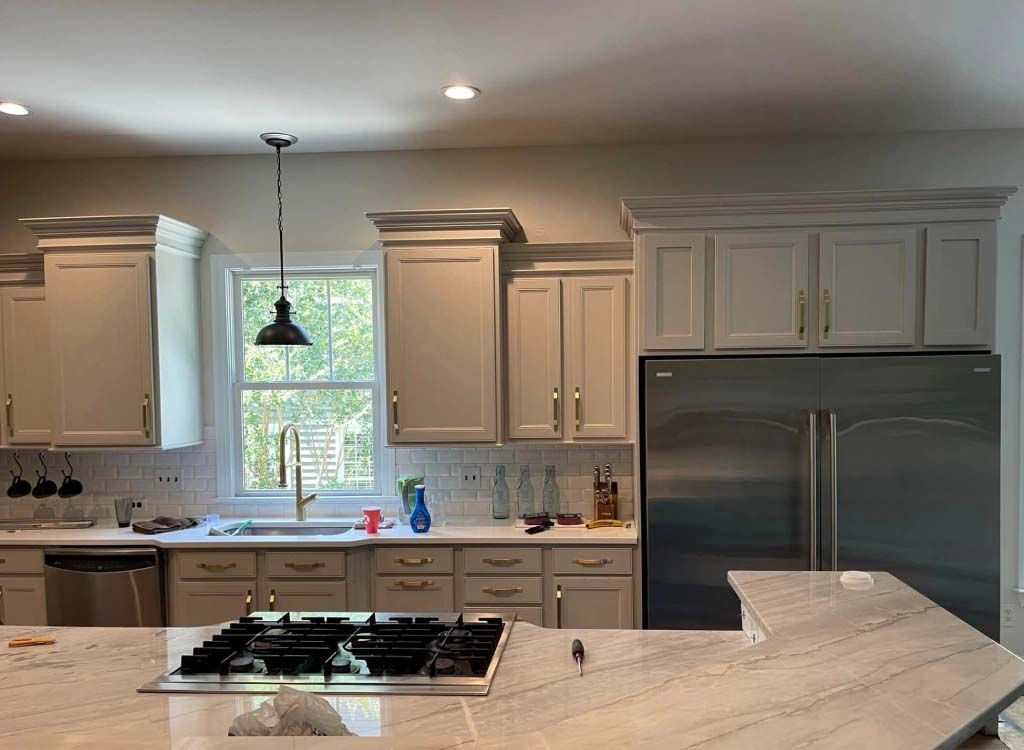 A kitchen with white cabinets and stainless steel appliances