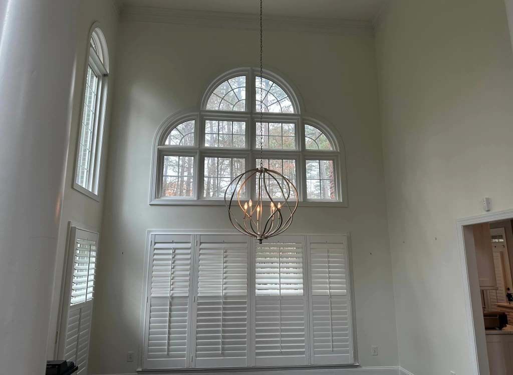 There is a chandelier hanging from the ceiling in the dining room.