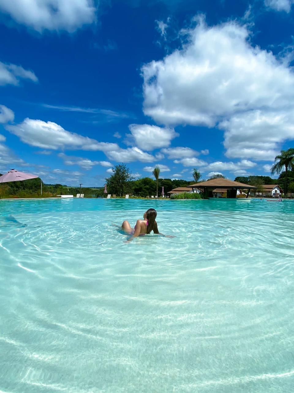 Uma mulher de biquíni está nadando em uma grande piscina
