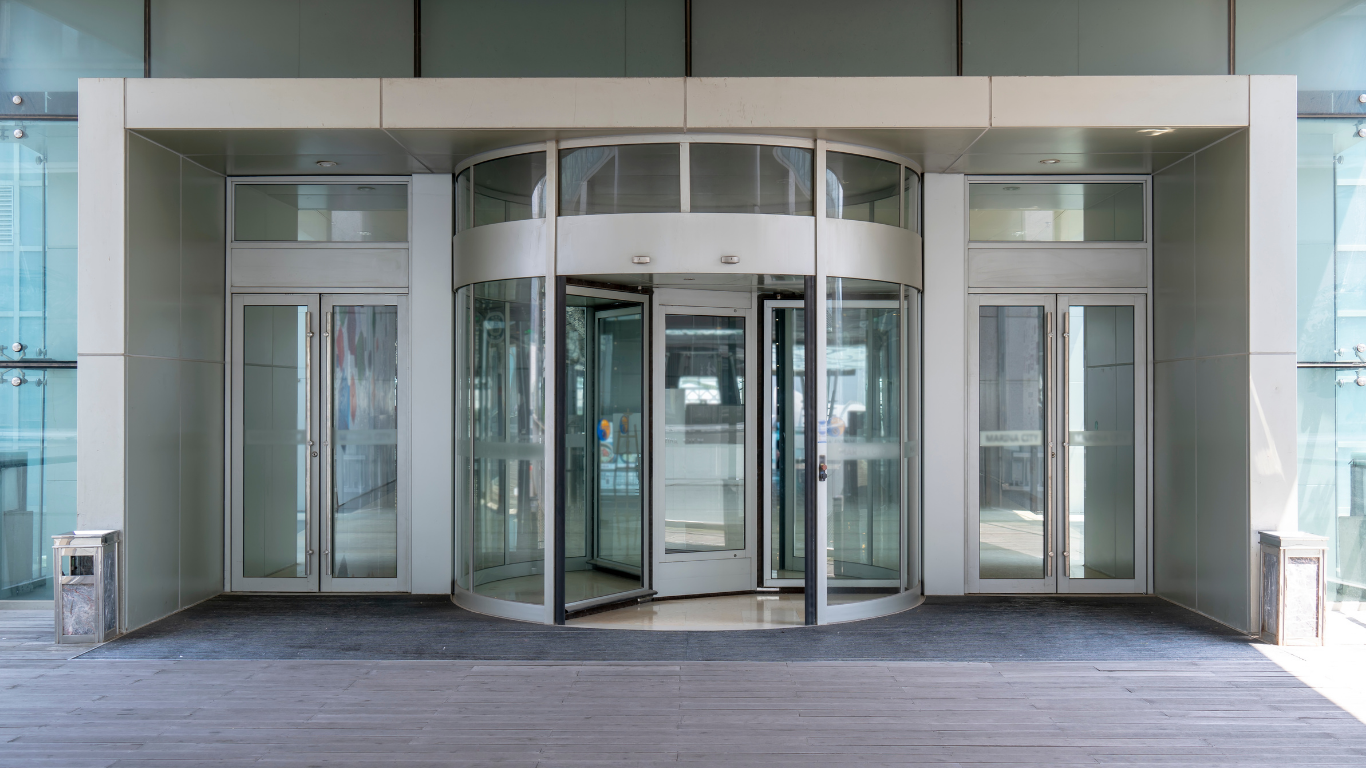 Revolving door at the entrance of a modern building, with glass panels and metal framing.