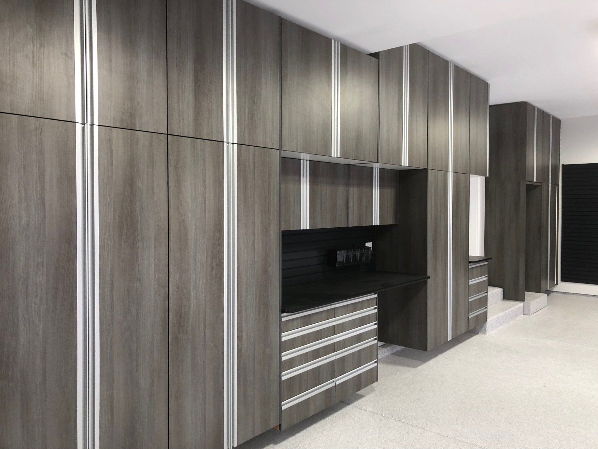 Gray and white modern garage storage cabinets and work area.