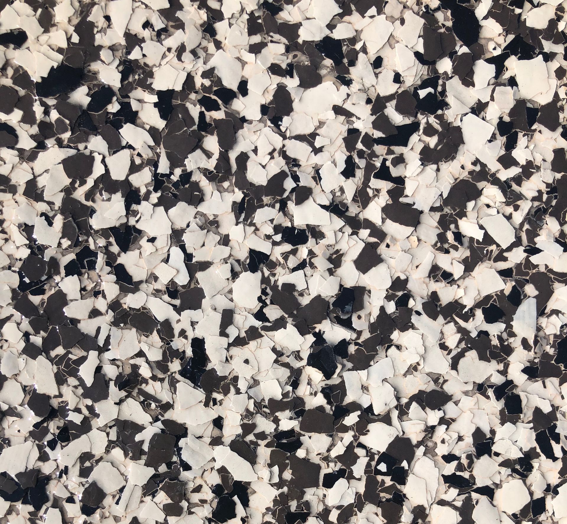 A close-up view of a floor with a speckled pattern of white, black, and gray chips.