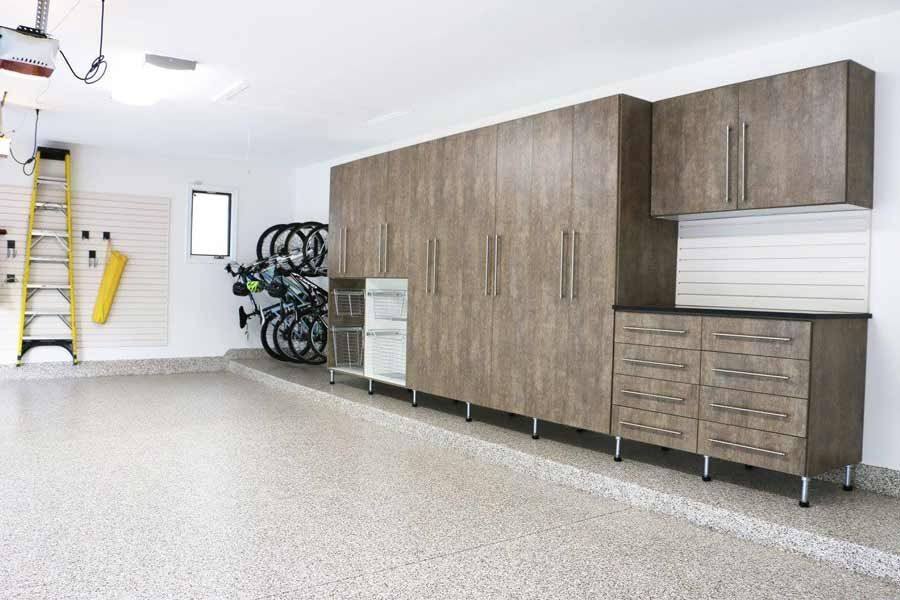 Garage interior with built-in storage cabinets, bikes, and a ladder.