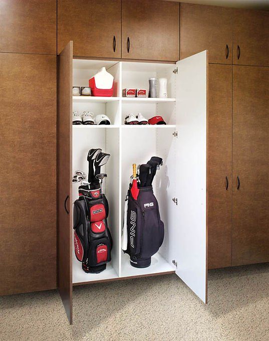 Garage cabinet with golf bags and shelves holding golf accessories.