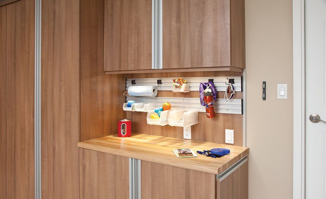 Dog supply station with cabinets, countertop, wall organizers, and accessories.