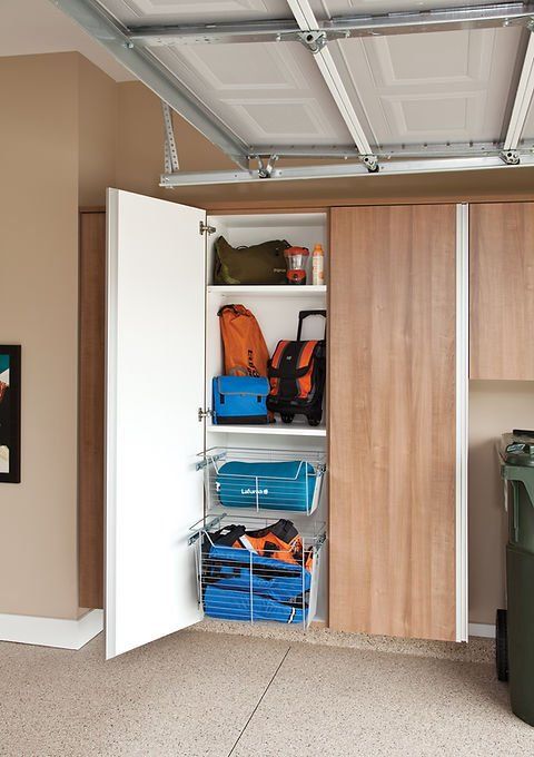Garage storage cabinet with open white door, revealing shelves with equipment.
