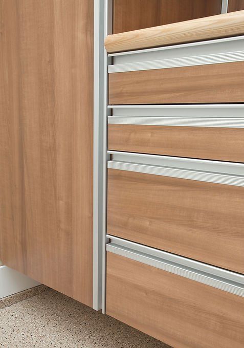 Wooden drawers with silver handles and trim in a cabinet.