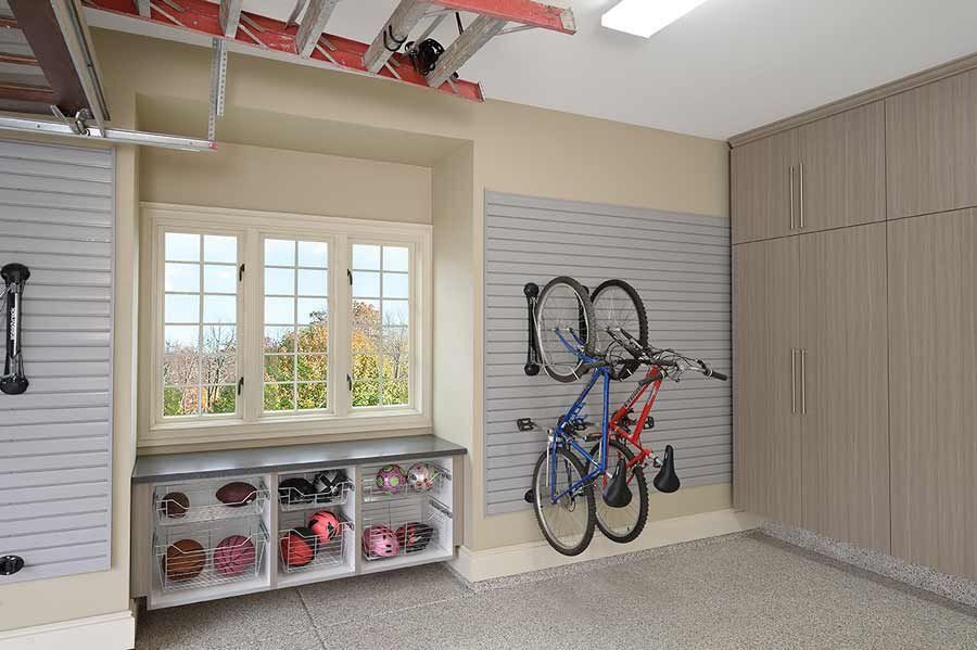 Garage with wall-mounted storage and bike, window, and cabinets.