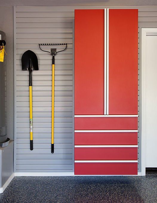 Garage wall with gray slats, red cabinet with drawers, and tools.